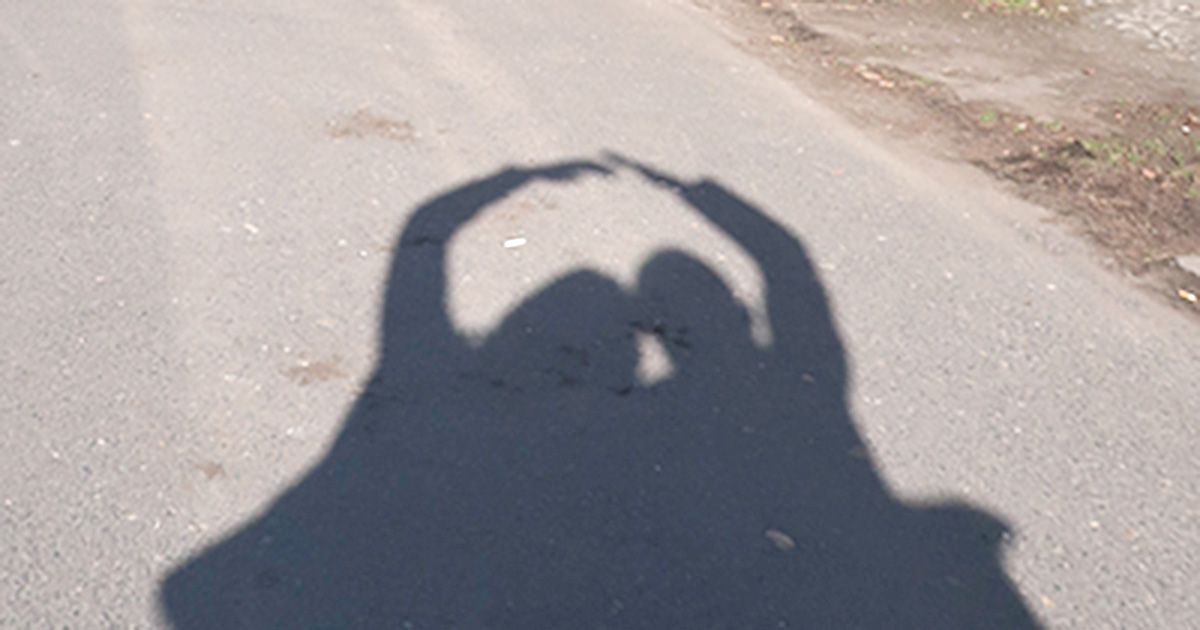 Dvě postavy se zvednutýma rukama tvořící most - symbol -podpora pro znevýhodněné - rodiny s autismem